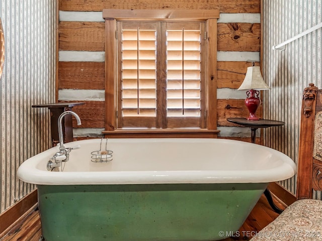 bathroom with a tub to relax in and hardwood / wood-style floors