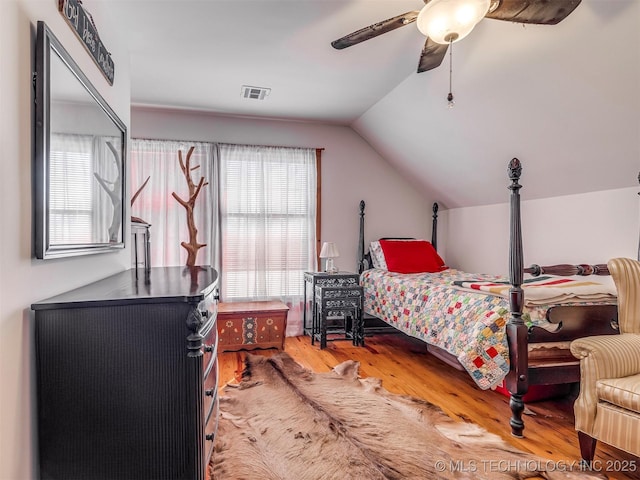 bedroom featuring multiple windows, lofted ceiling, hardwood / wood-style floors, and ceiling fan