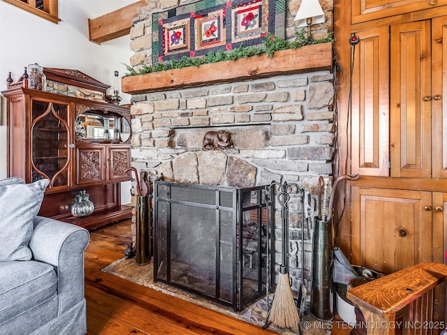 living room featuring a fireplace, beamed ceiling, and dark wood-type flooring