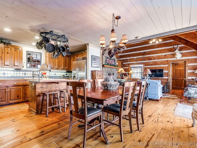 dining space with light hardwood / wood-style flooring, wood ceiling, and an inviting chandelier