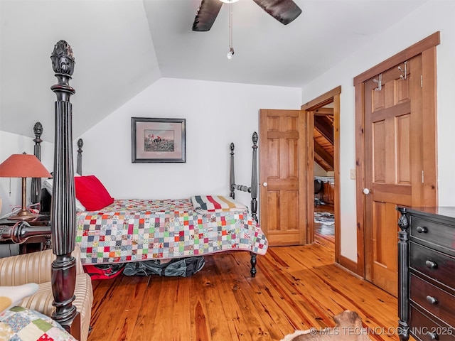 bedroom featuring ceiling fan, light wood-type flooring, and lofted ceiling