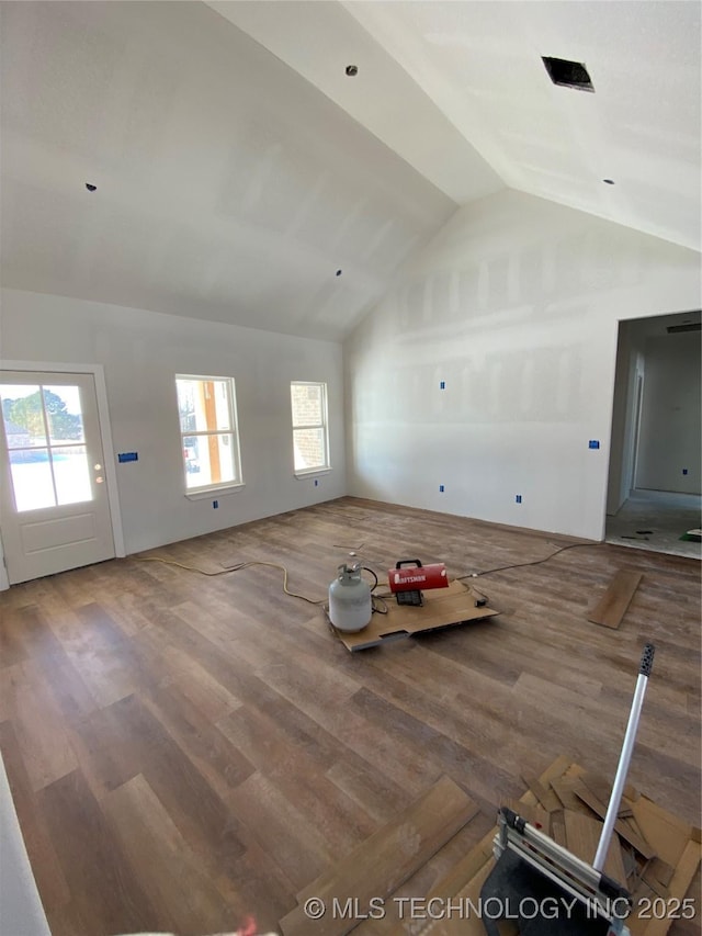 unfurnished living room featuring lofted ceiling and wood-type flooring