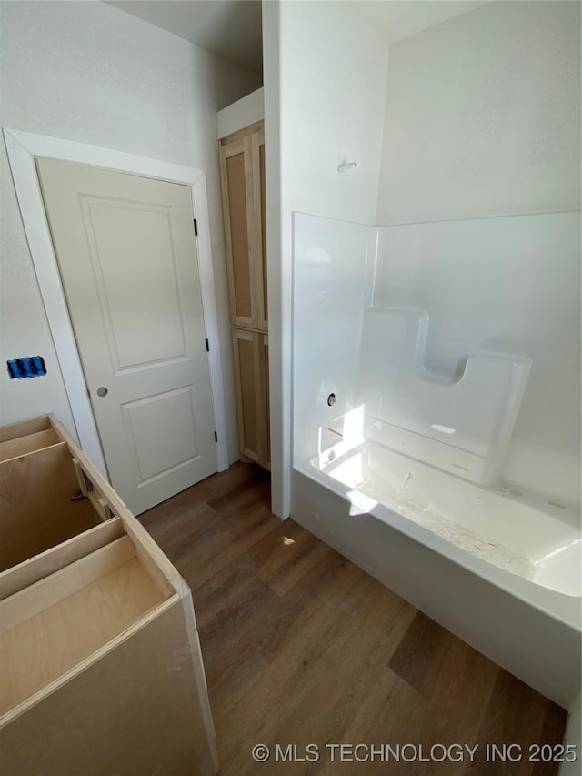 bathroom with a bathtub and wood-type flooring