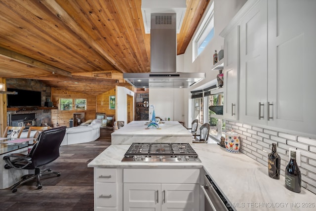 42900 W 11th St, Terlton, OK 74081 - kitchen with island range hood, stainless steel gas stovetop, plenty of natural light, dark wood-style flooring, and wooden walls