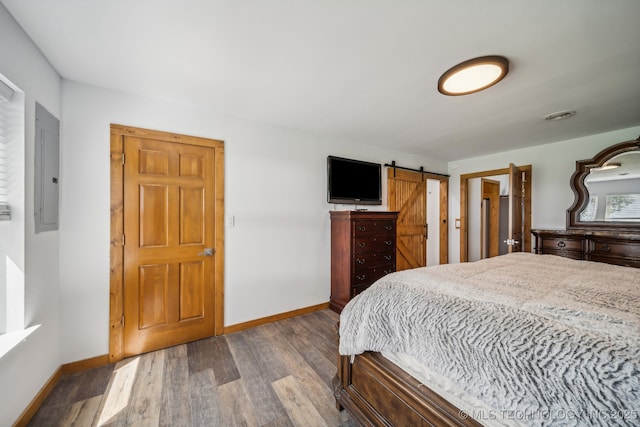 42900 W 11th St, Terlton, OK 74081 - bedroom featuring dark wood-style flooring, baseboards, a barn door, and electric panel
