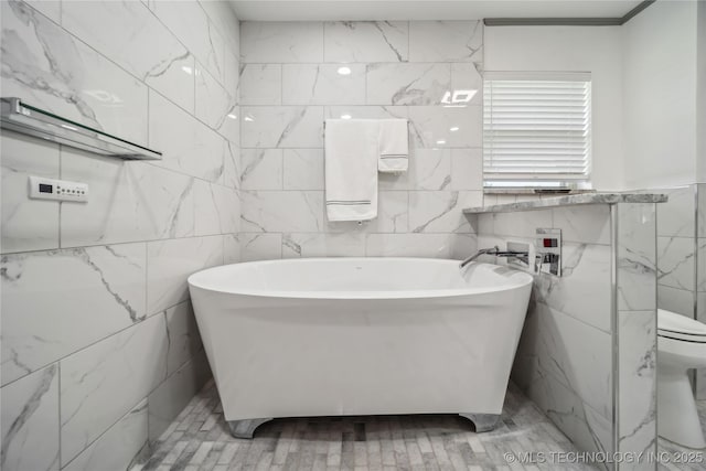 bathroom featuring tile walls, toilet, and a bath