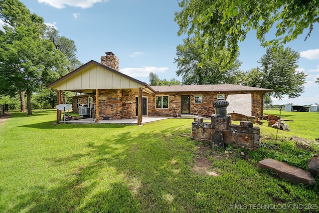 42900 W 11th St, Terlton, OK 74081 - rear view of house featuring a chimney, stone siding, a patio area, and a lawn