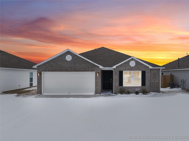 view of front of home featuring a garage, central AC, and brick siding