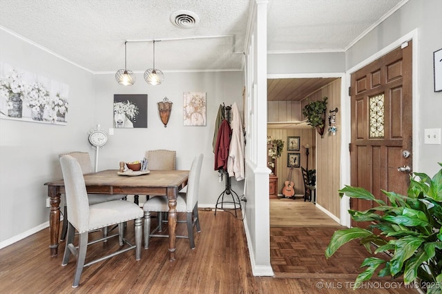 dining room featuring visible vents, a textured ceiling, and ornamental molding