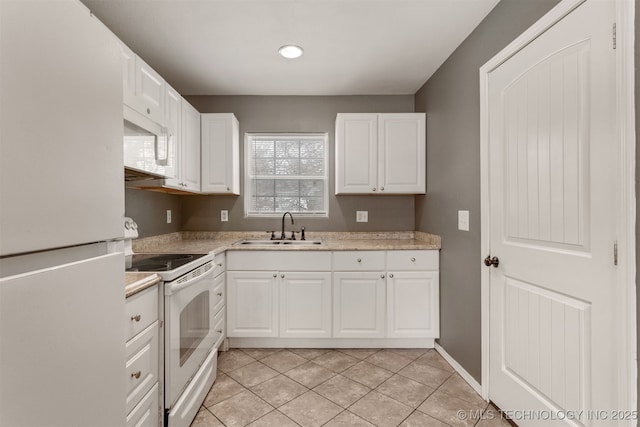 kitchen with white appliances, white cabinetry, a sink, and light tile patterned flooring