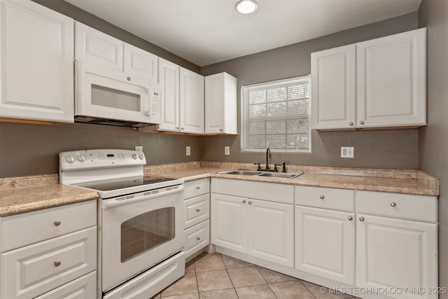 kitchen with light tile patterned floors, white appliances, a sink, white cabinets, and light countertops