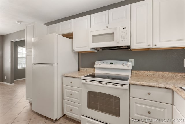 kitchen with light tile patterned floors, light countertops, white cabinets, white appliances, and baseboards