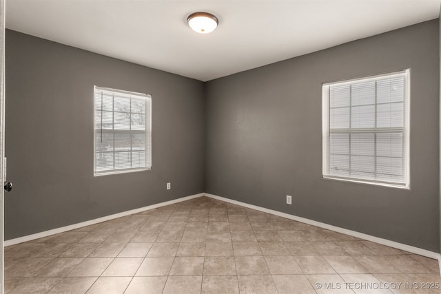 empty room with light tile patterned floors and baseboards