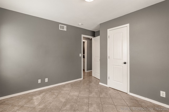 unfurnished bedroom featuring visible vents, baseboards, and light tile patterned flooring