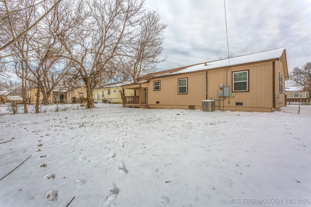 snow covered back of property with crawl space and central air condition unit