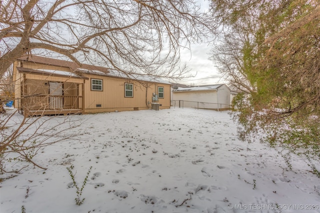 snow covered house featuring crawl space