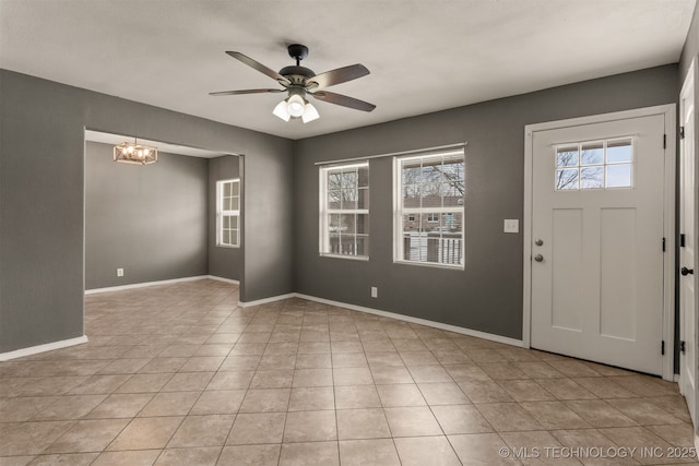 entrance foyer with light tile patterned floors, ceiling fan with notable chandelier, and baseboards