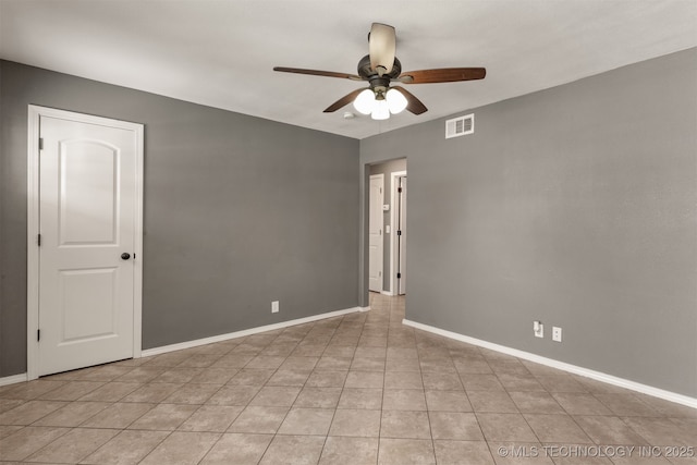 unfurnished room with light tile patterned floors, a ceiling fan, visible vents, and baseboards