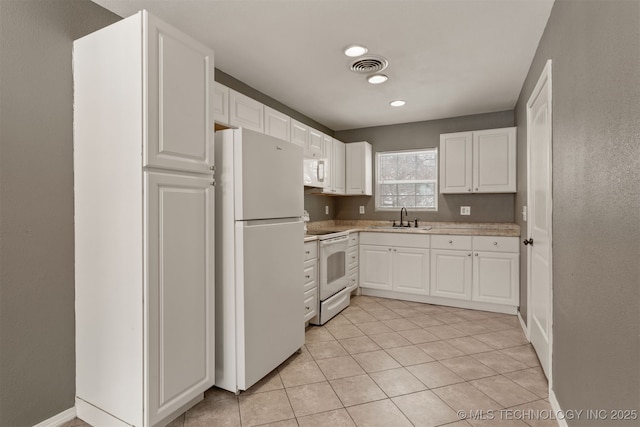 kitchen featuring light countertops, white appliances, white cabinetry, and visible vents