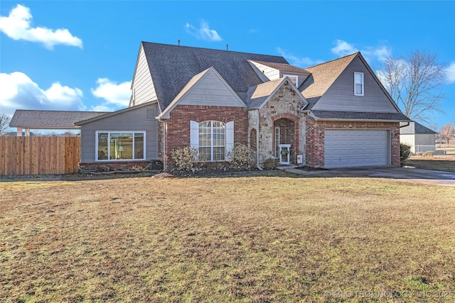 traditional home with driveway, roof with shingles, fence, a front lawn, and brick siding