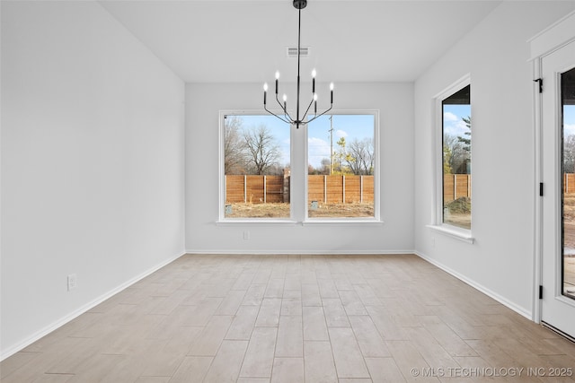 unfurnished dining area featuring a notable chandelier, baseboards, visible vents, and light wood-style floors