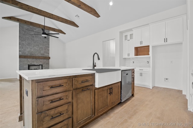 kitchen featuring a center island with sink, white cabinets, dishwasher, lofted ceiling with beams, and glass insert cabinets