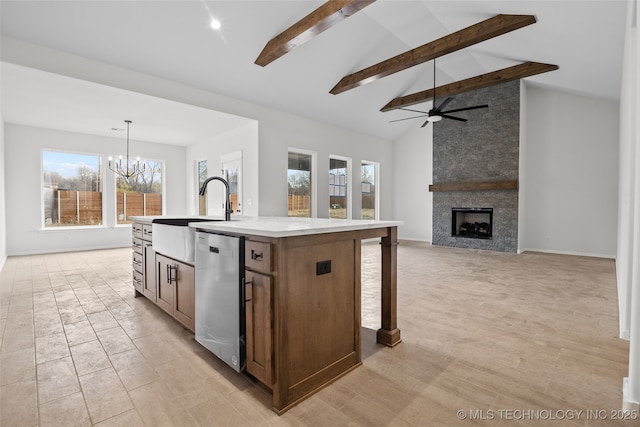 kitchen with a center island with sink, light countertops, hanging light fixtures, open floor plan, and dishwasher