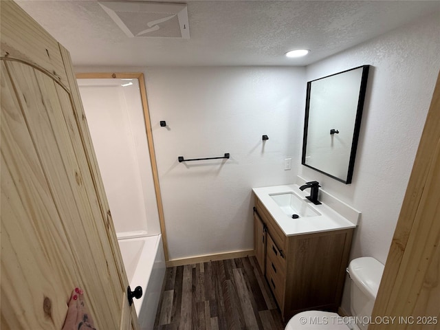 full bath featuring a textured ceiling, toilet, wood finished floors, vanity, and visible vents