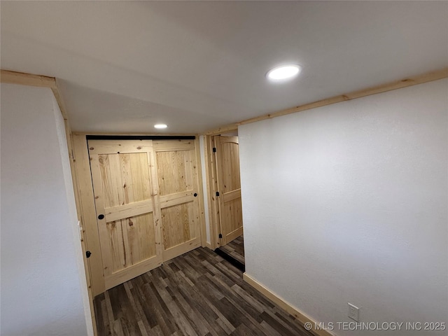 hall featuring recessed lighting, dark wood finished floors, and baseboards