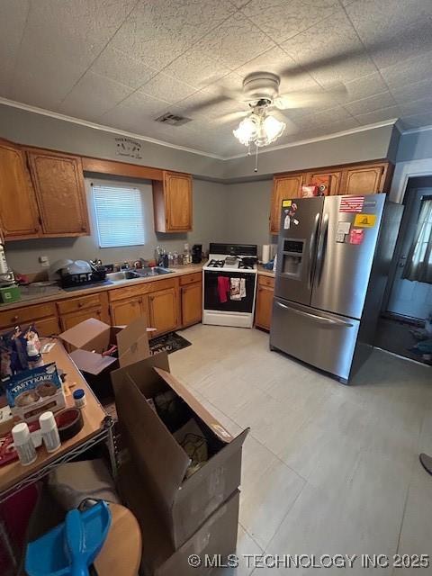 111 N 47th W Ave, Tulsa, OK 74127 - kitchen featuring brown cabinetry, stainless steel fridge, light countertops, and white gas stove
