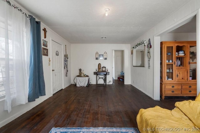 living area featuring visible vents and wood finished floors