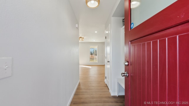 corridor with wood finished floors and baseboards