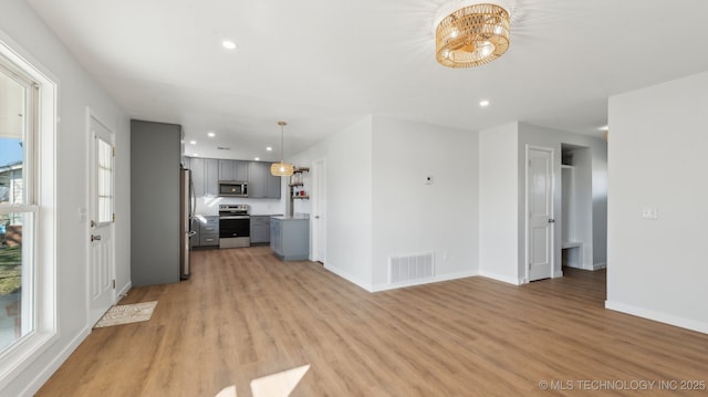 kitchen with visible vents, appliances with stainless steel finishes, gray cabinets, light countertops, and light wood-style floors