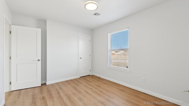 unfurnished bedroom featuring light wood-style flooring, visible vents, and baseboards