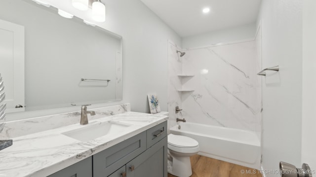 bathroom featuring tub / shower combination, vanity, toilet, and wood finished floors