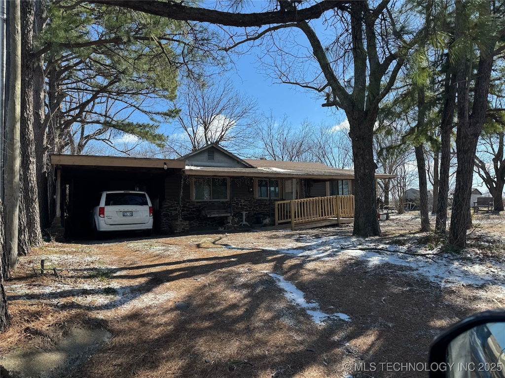 ranch-style home featuring a carport, driveway, and a porch