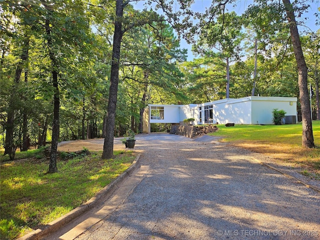 view of front of property featuring gravel driveway and a front lawn