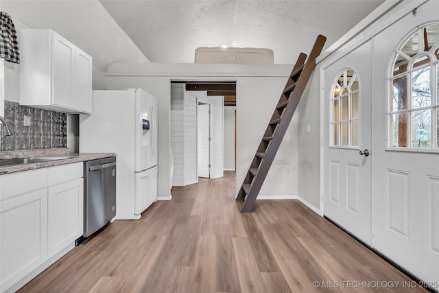 kitchen featuring light wood finished floors, light countertops, white cabinets, a sink, and dishwasher