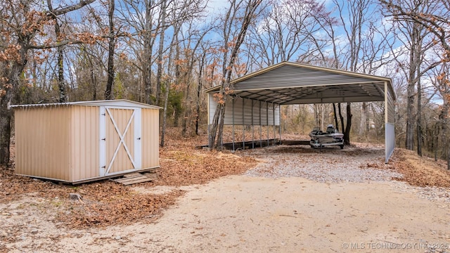 view of shed with a carport and driveway