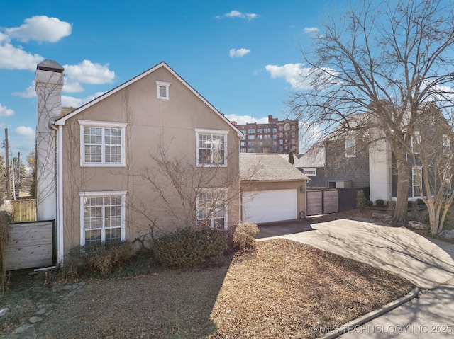 view of front of property featuring concrete driveway, a chimney, an attached garage, and stucco siding