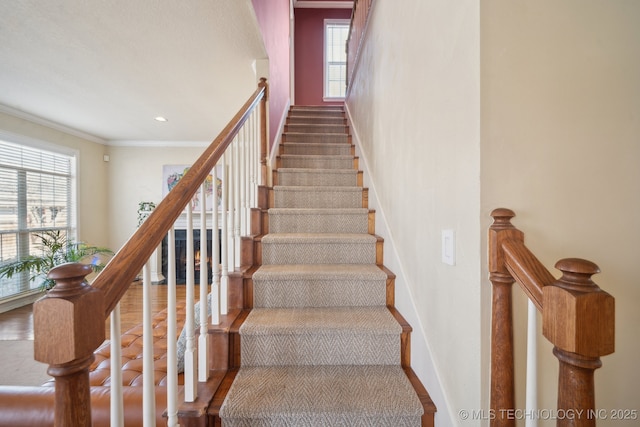 stairway featuring crown molding, recessed lighting, plenty of natural light, and baseboards