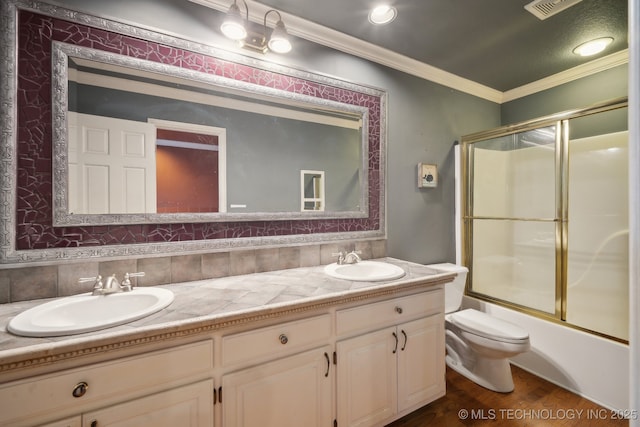 bathroom with toilet, crown molding, double vanity, and a sink