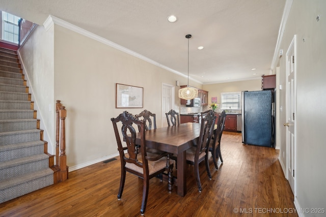 dining area featuring crown molding, recessed lighting, dark wood-style floors, and stairs