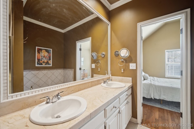 bathroom featuring a sink, ensuite bathroom, double vanity, and crown molding