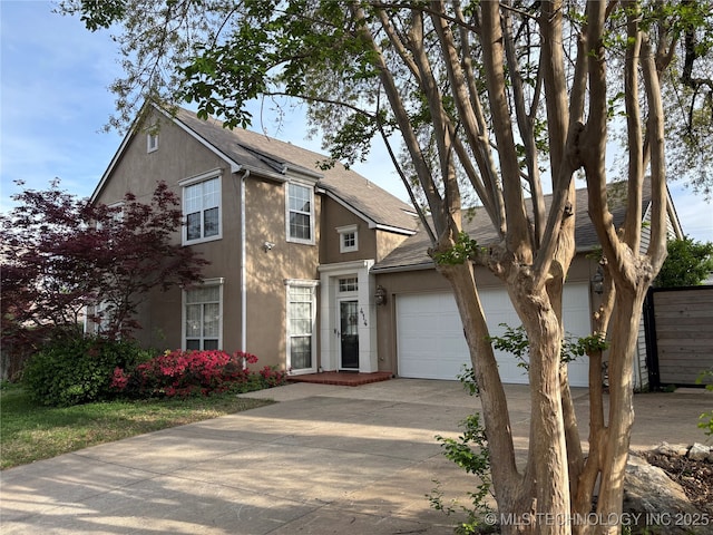 view of front facade with roof with shingles, an attached garage, stucco siding, and concrete driveway