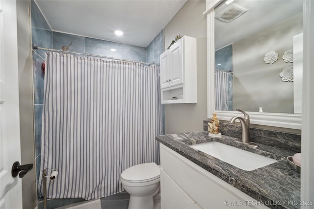 bathroom featuring curtained shower, visible vents, vanity, and toilet