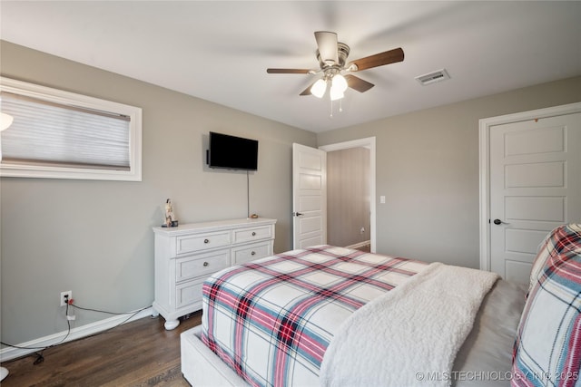 bedroom featuring dark wood-style floors, a ceiling fan, visible vents, and baseboards