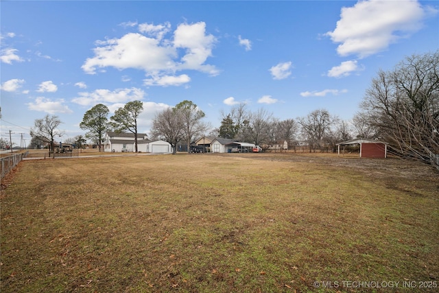 view of yard featuring a garage and fence