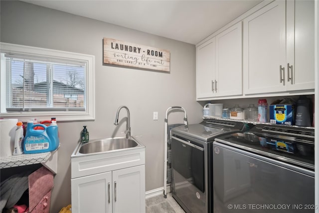 laundry area featuring cabinet space, a sink, and separate washer and dryer