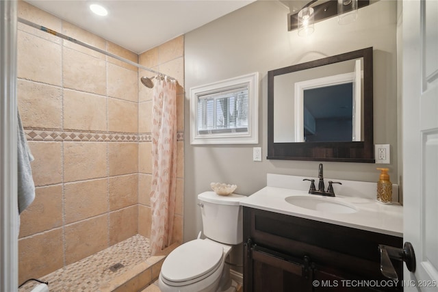 bathroom featuring a stall shower, vanity, and toilet